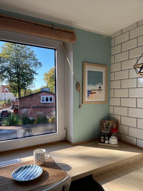 een kamer met een groot raam en een tafel bij Brezno Apartament in Gdańsk