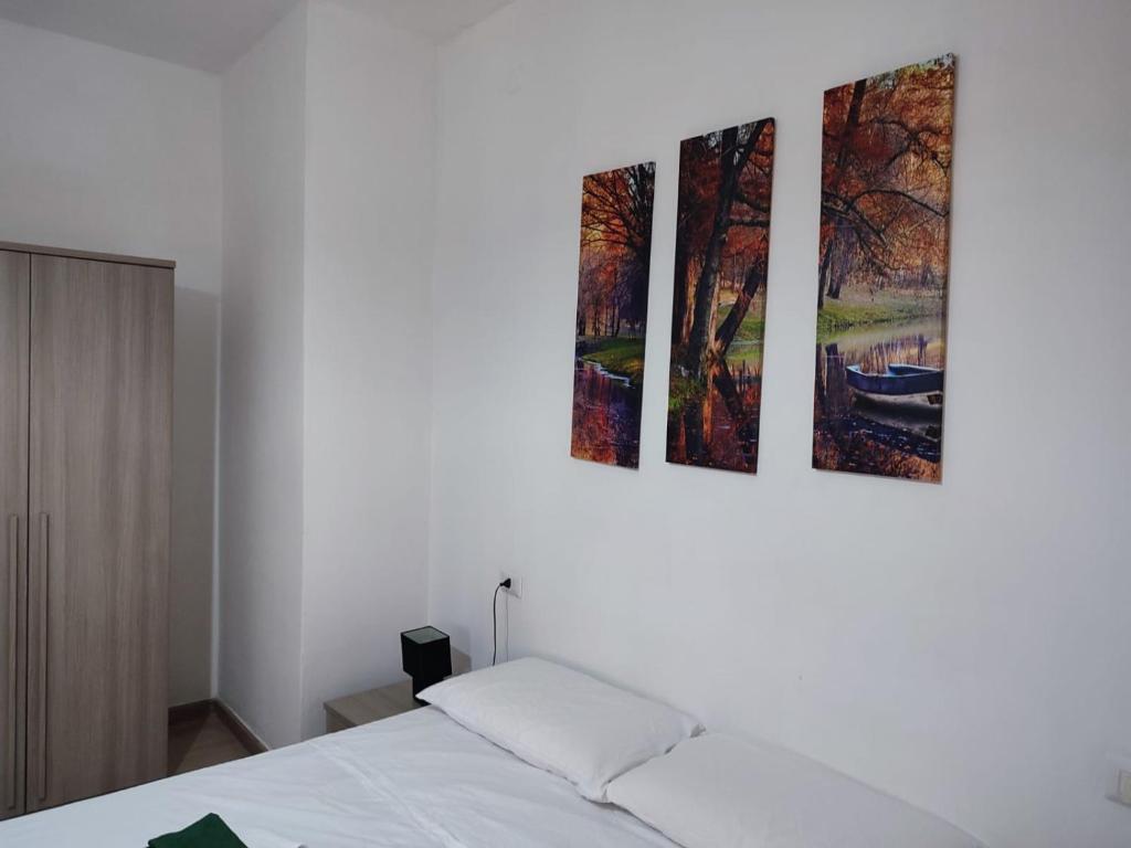 a bedroom with three pictures hanging on the wall at Rooms for rent 67 in Sassari