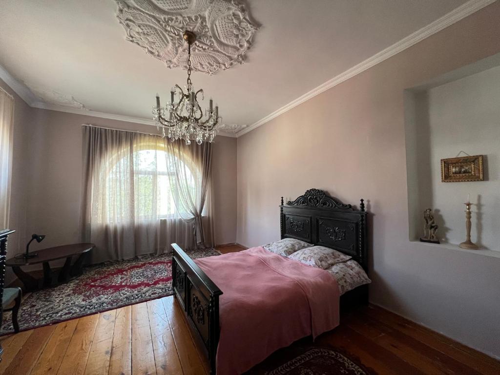 a bedroom with a bed and a chandelier at MARIMO in Kutaisi