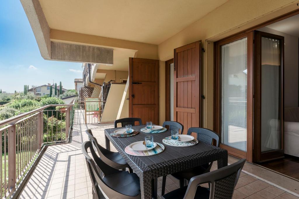 einen Tisch und Stühle auf dem Balkon eines Hauses in der Unterkunft QUIET PLACE close to city center in Desenzano del Garda
