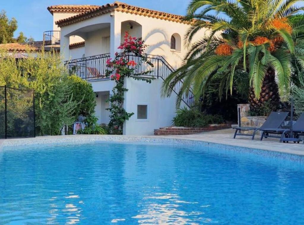 a villa with a swimming pool in front of a house at Maxima Sunset in Sainte-Maxime