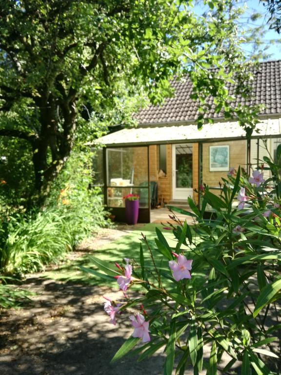 une maison avec un jardin fleuri devant elle dans l'établissement Chemin des Poètes, à Nevers