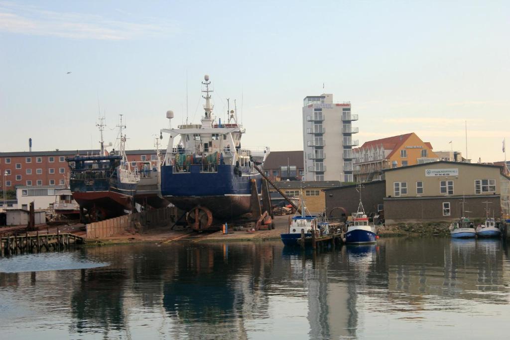a group of boats are docked in a harbor at Seafront Hotel in Hirtshals