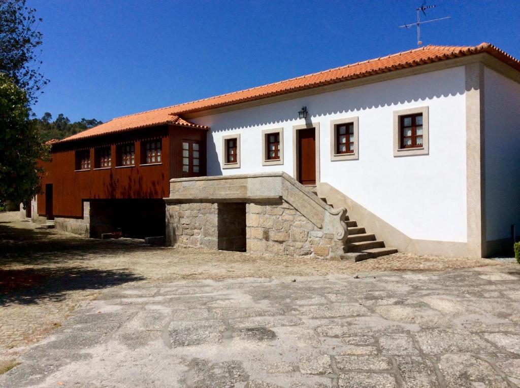 un grand bâtiment blanc avec un escalier en face de celui-ci dans l'établissement Casa da Eira, à Baião