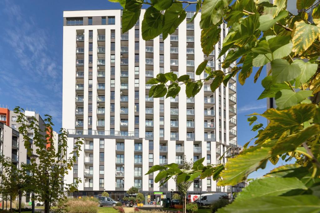 un alto edificio bianco con alberi di fronte di Mogilska Apartments by Renters Prestige a Cracovia