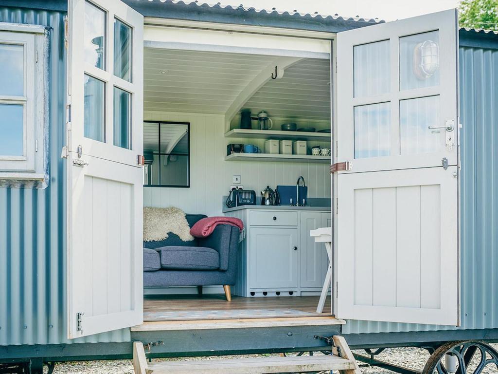 an open door of a tiny house with a couch at Phoebes Folly-uk36581 in Milton Abbot