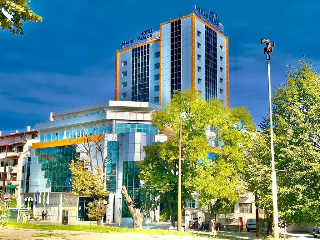 ein hohes Gebäude mit einem Schild darüber in der Unterkunft Merian Palace Hotel in Stara Sagora