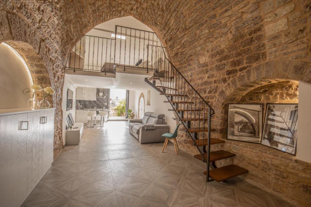 a living room with a spiral staircase in a brick wall at C'era una volta in Assisi