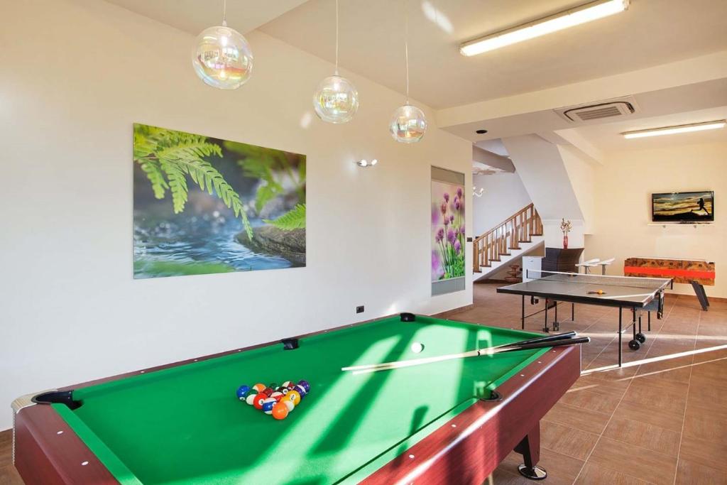 pokój przy basenie ze stołem bilardowym i piłkami do ping ponga w obiekcie Villa Diora - Home & Spa w mieście Karojba