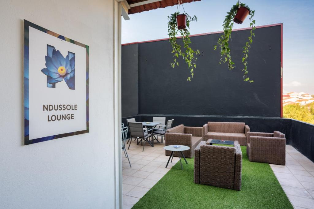- une salle d'attente avec des tables, des chaises et un tableau noir dans l'établissement Ndussole Guest House, à Porto