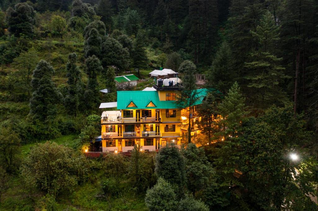 un gran edificio con techo azul en una colina en The Hosteller Kasol en Kasol