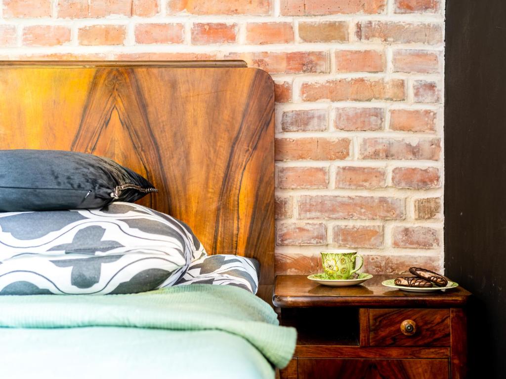 托伦Apartament Kraszewskiego 44 z balkonem, cegła- koło parku, ogród dla gości, rowery free的砖墙卧室,配有一张床和砖墙