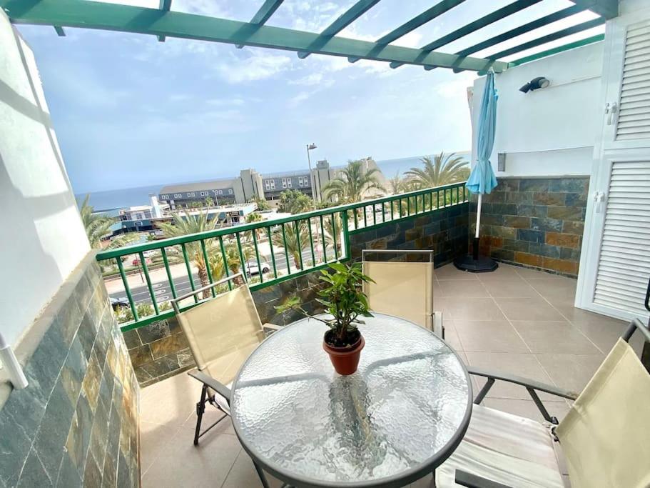 einen Glastisch mit einer Topfpflanze auf dem Balkon in der Unterkunft Apartamento vista mar en Flamboyan - San Agustín in San Bartolomé de Tirajana