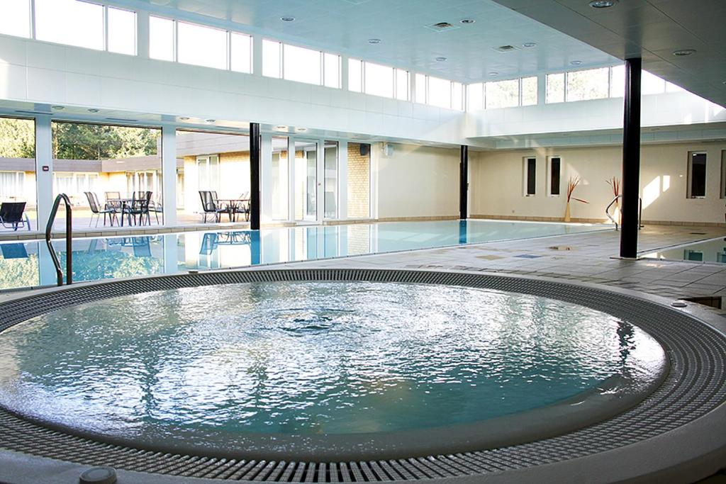 a large swimming pool with a large tub in a building at Hotel Marina in Grenå