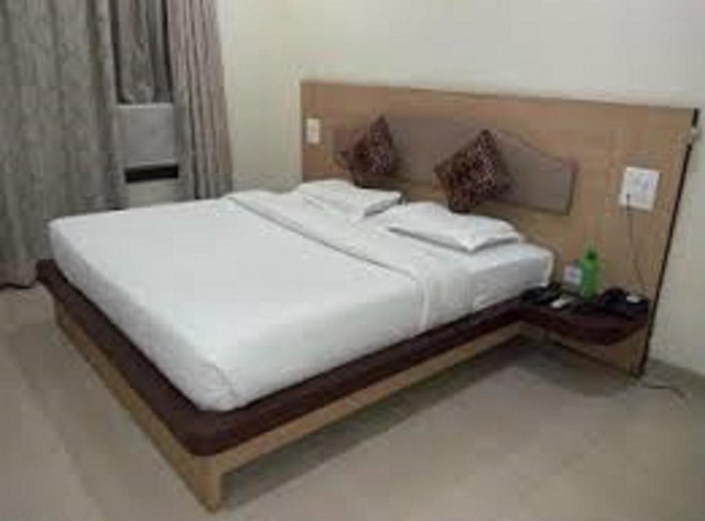 a bedroom with a large white bed in a room at Hotel Sukhakarta, Nagpur in Nagpur