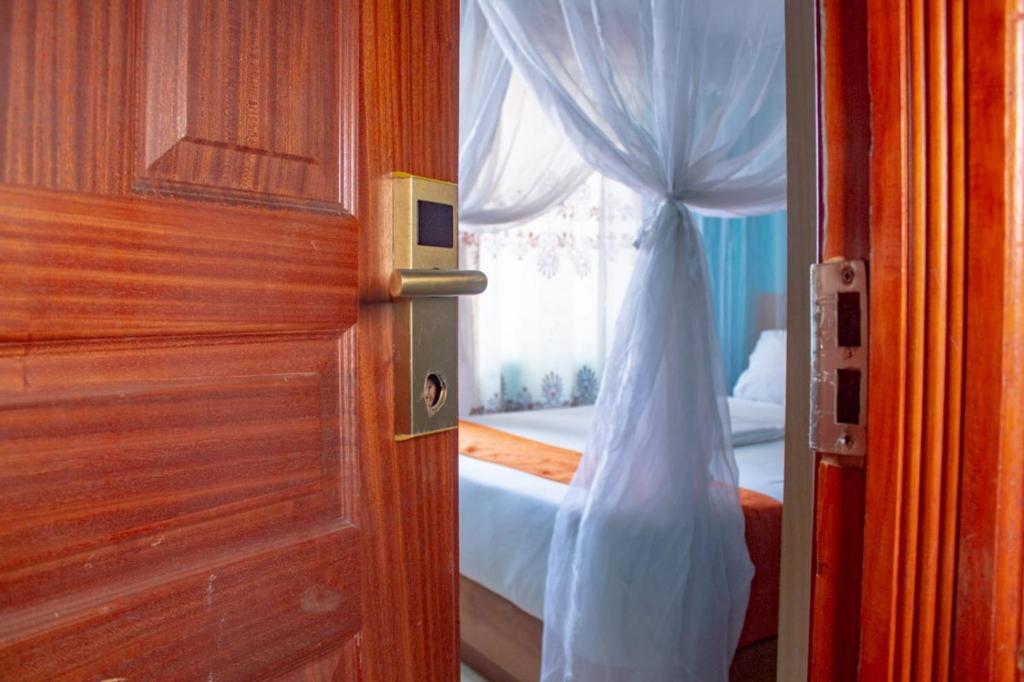 Deka Self Contained Rooms في نيروبي: باب مفتوح لغرفة نوم مع سرير