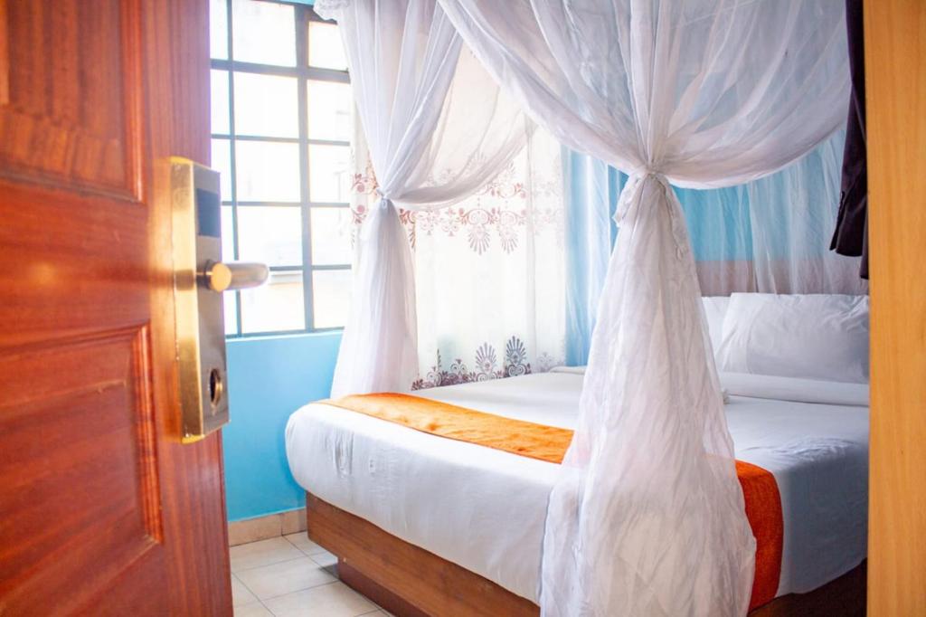a bedroom with a canopy bed with a window at Deka Self Contained Rooms in Nairobi