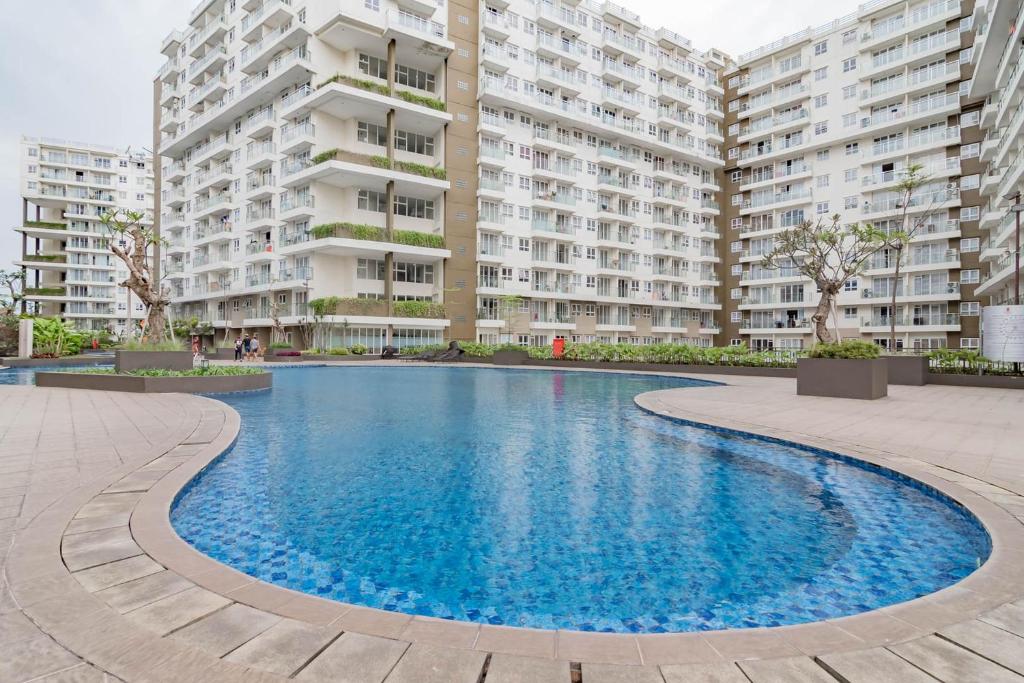 a swimming pool in front of a large apartment building at RedLiving Apartemen Gateway Pasteur - TN Hospitality 3 Tower Jade B in Bandung