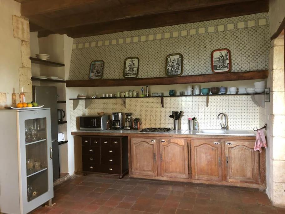 a kitchen with wooden cabinets and a sink at Gîte de L’Edelinie in Nanteuil-de-Bourzac