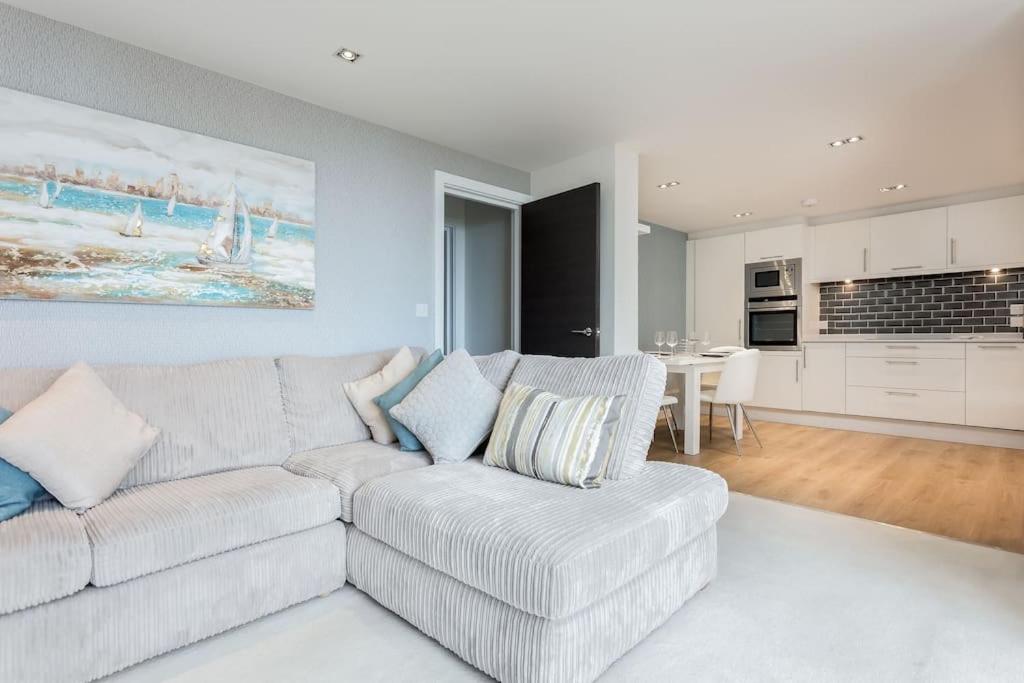 a living room with a couch and a kitchen at Stunning 2 bed apartment, fabulous sea view & 2 minutes to beach with parking in Southbourne