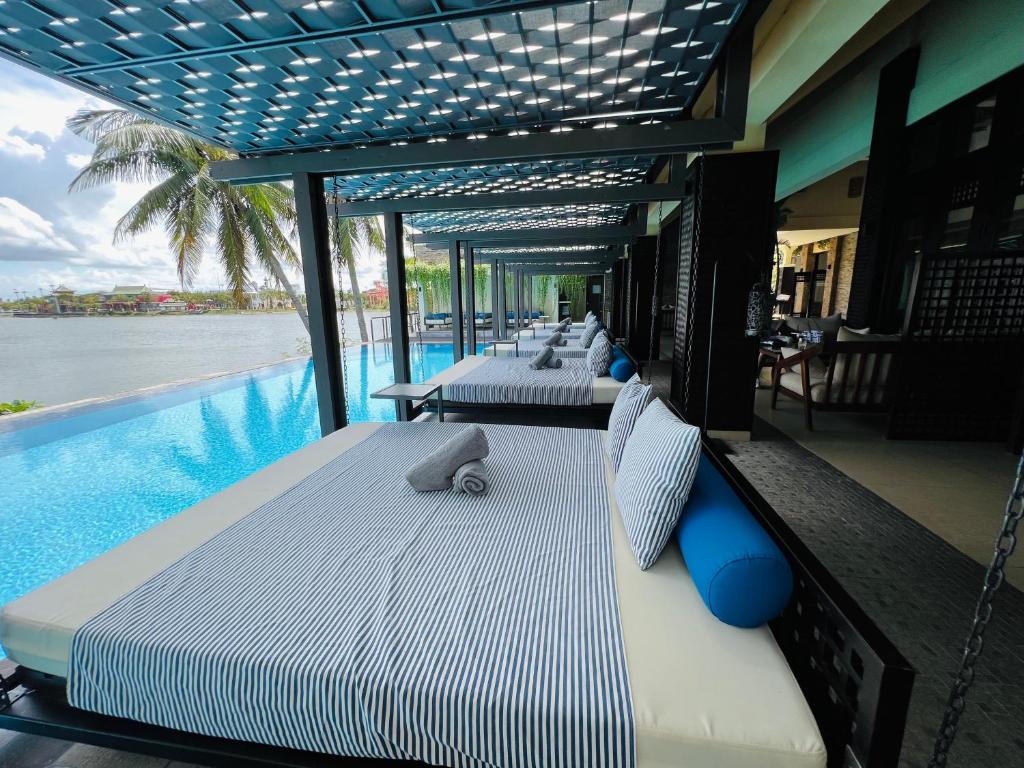 una habitación de hotel con varias camas y una piscina en THE BLOSSOM RESORT ISLAND - All Inclusive, en Da Nang