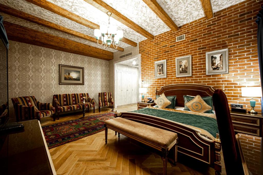 ein Schlafzimmer mit einem Bett in einer Ziegelwand in der Unterkunft Sapphire Bayil Hotel in Baku