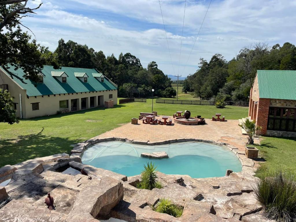 a large pool in a yard next to a building at Soloko Game farm in Kareedouw