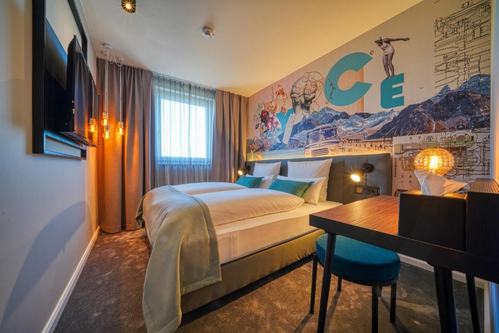 um quarto de hotel com uma cama e uma secretária em NYCE Hotel Ulm em Ulm