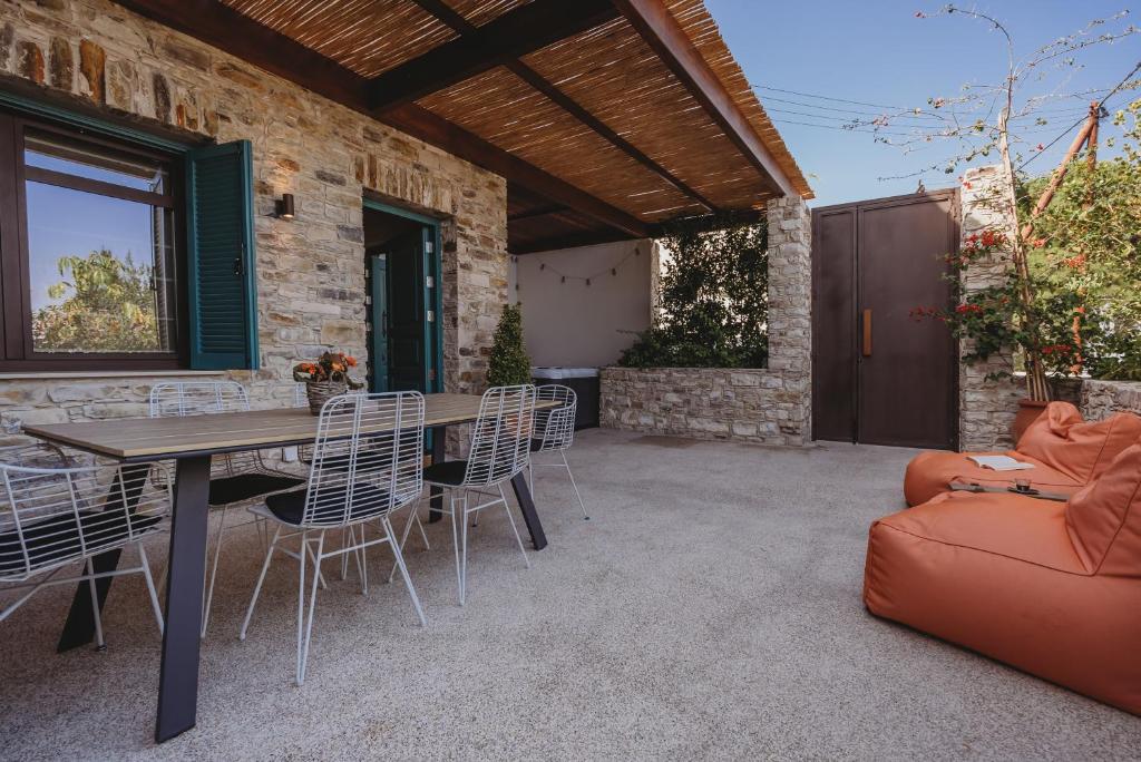 un patio con mesa de madera y sillas en Lefkara Luxury Suites, en Pano Lefkara