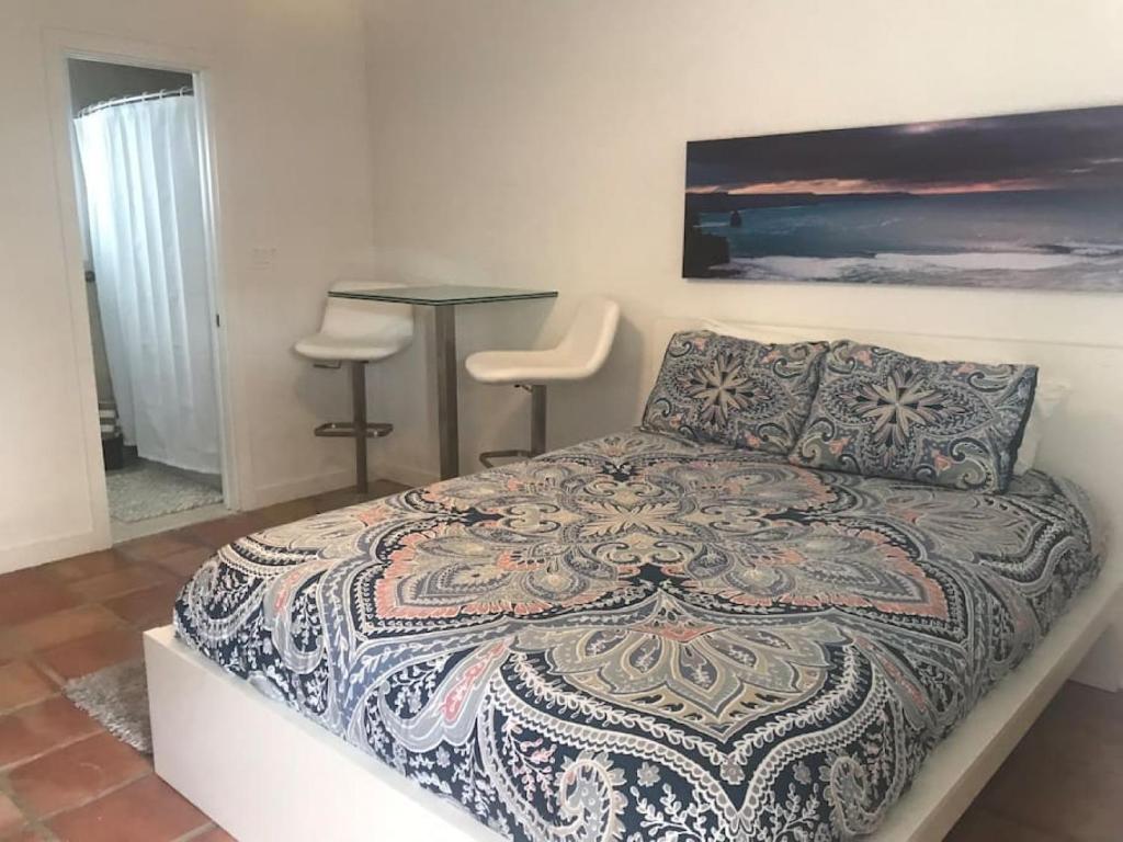 a bedroom with a bed and a table and stool at Efficiency 3 on water Las Olas beach and free kayaks in Fort Lauderdale