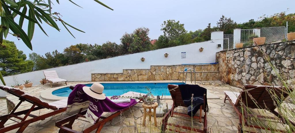 a patio with two chairs and a swimming pool at Apartment Nikola in Jelsa