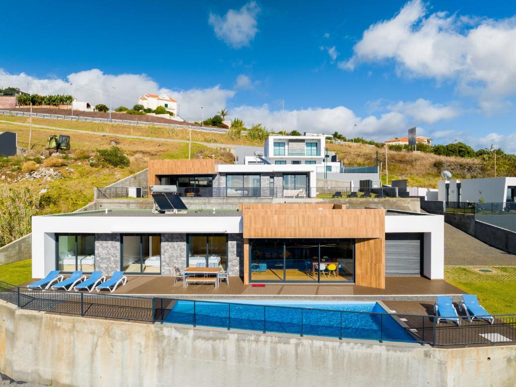 a house on a hill with a swimming pool at Casa Mozart II in Estreito da Calheta