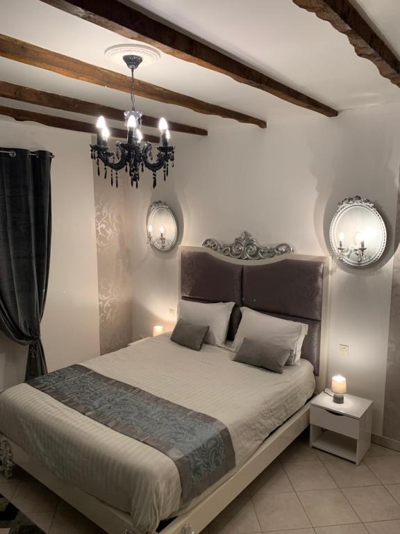 a bedroom with a large bed and a chandelier at La biche au bois chambres d hôtes in Cazals