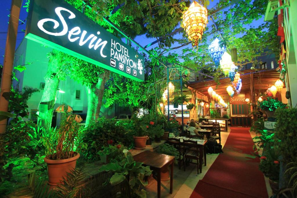 ボドルム・シティにあるセヴィン ホテル ペンションのたくさんの植物とテーブルが並ぶレストラン