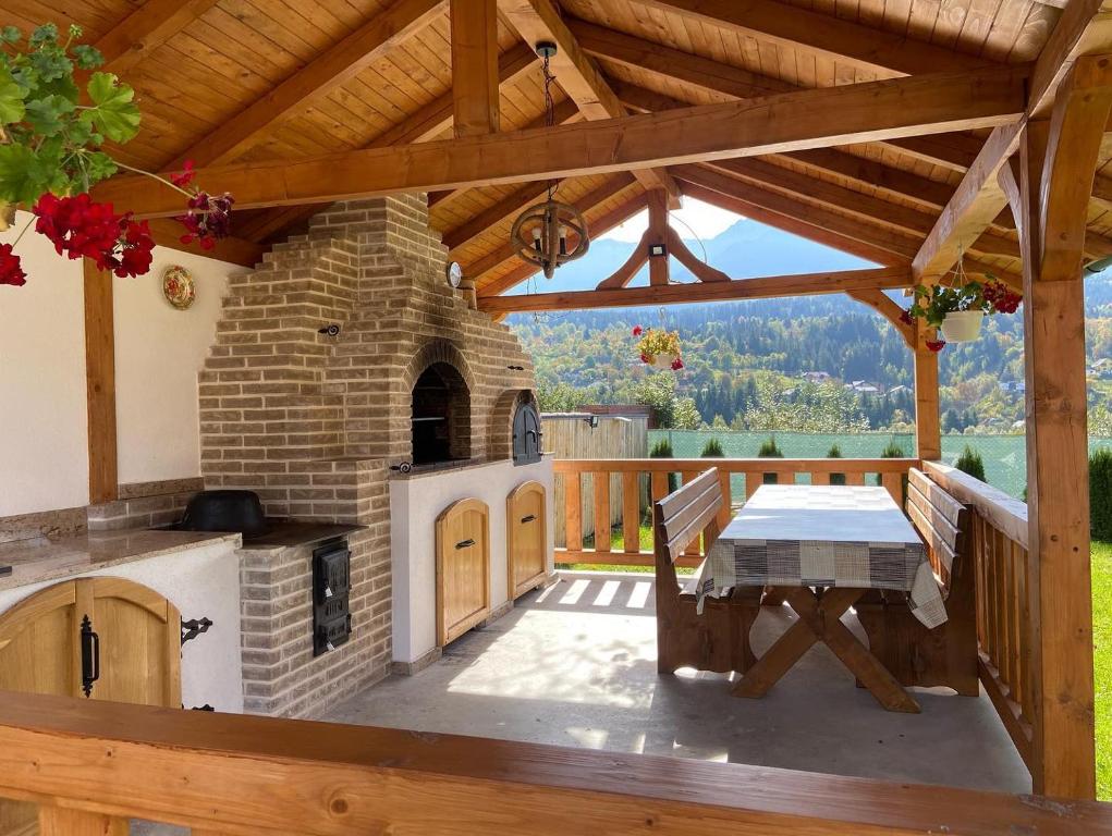 a patio with a stone oven and a table on a deck at Cabana 9 in Borşa