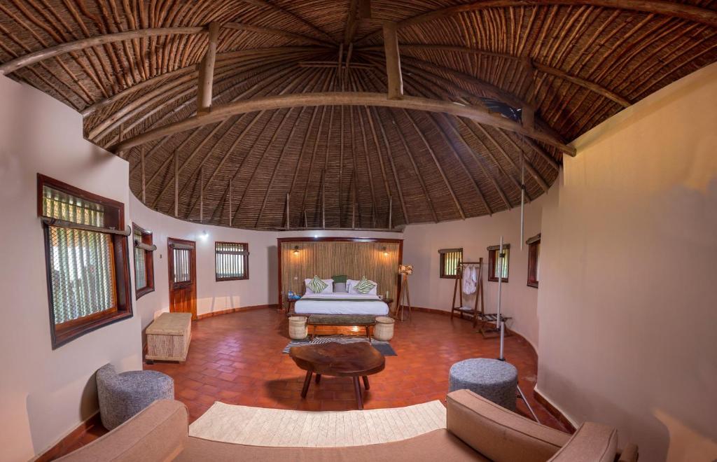 a large room with a bed and a large ceiling at Tilenga Safari Lodge in Arua