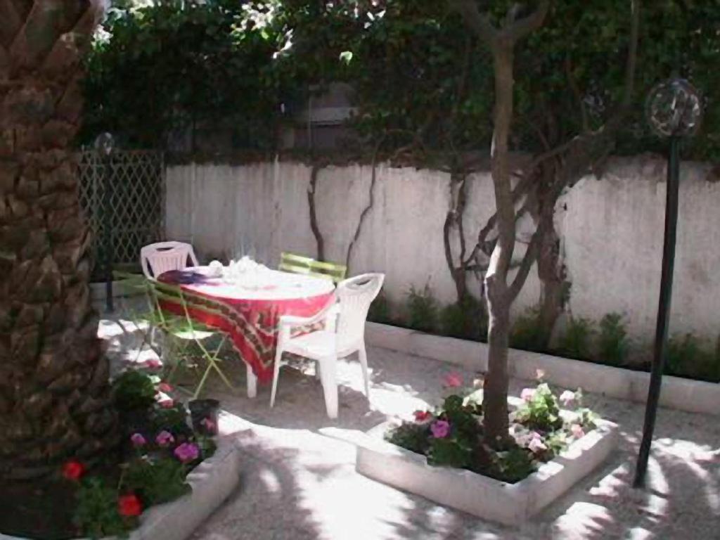 eine Terrasse mit einem Tisch, Stühlen und Blumen in der Unterkunft Casa Totti in Rom