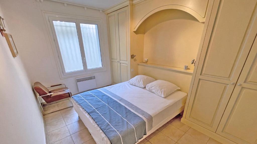 a small bedroom with a bed and a window at Miremer in Sainte-Maxime