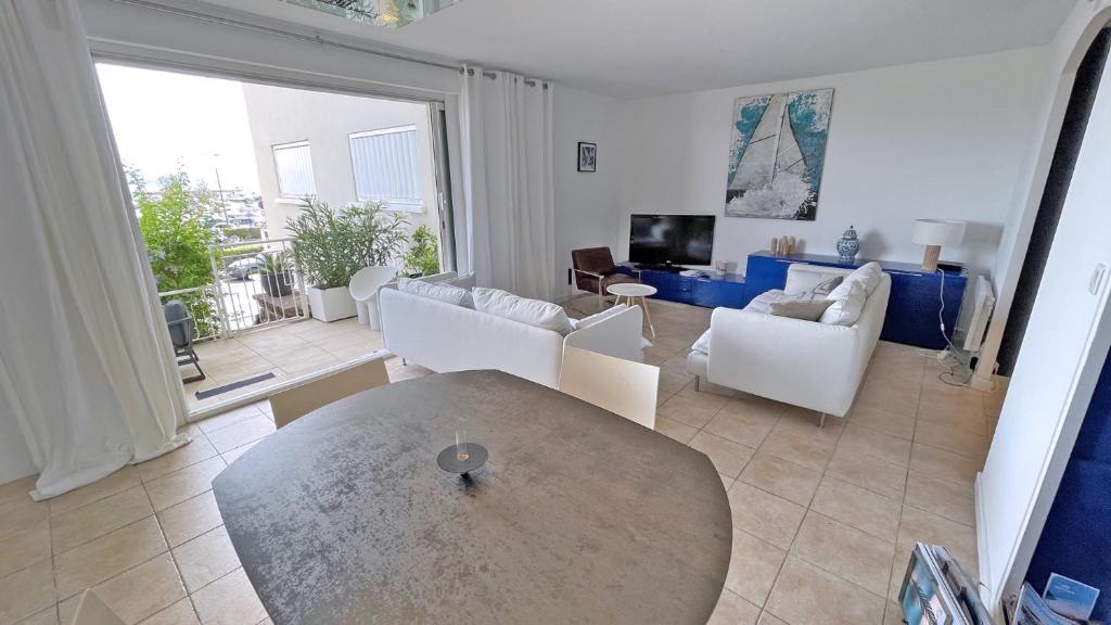 a living room with a table and white chairs at Miremer in Sainte-Maxime