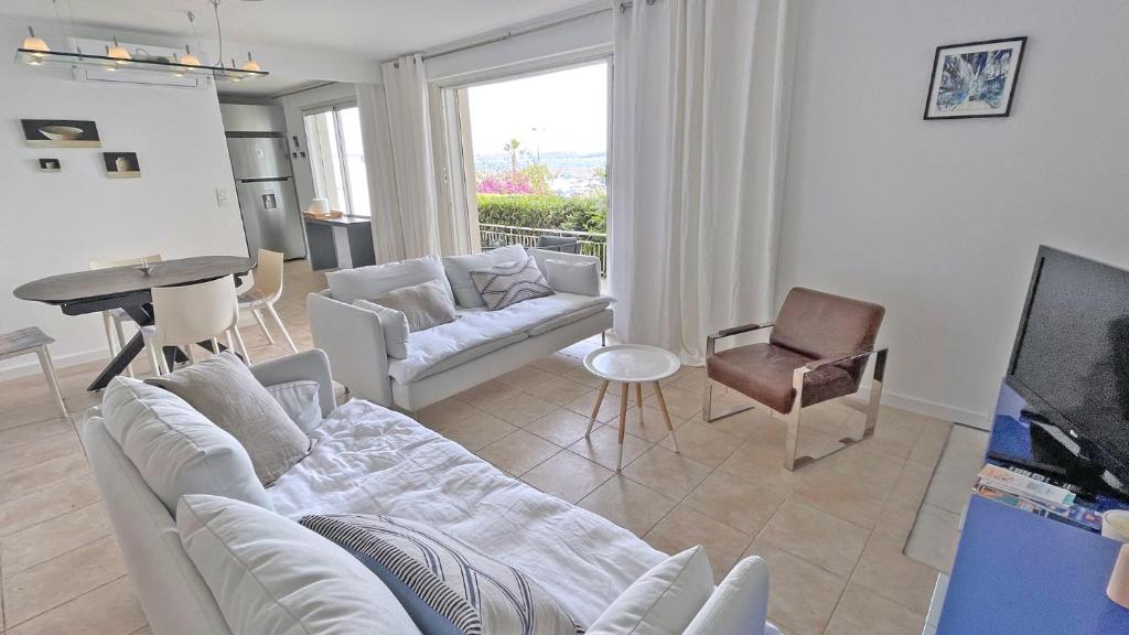a living room with a white couch and a piano at Miremer in Sainte-Maxime