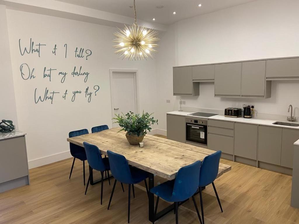 a kitchen with a wooden table and blue chairs at Apartment 5 4 bedrooms, sleeps x 15 in York