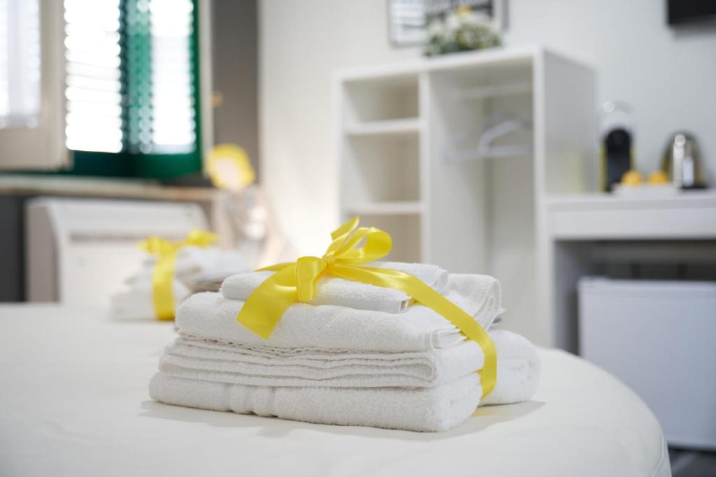 una pila di asciugamani con un fiocco giallo su un tavolo di B&B Milleduecento Luxury Room a Salerno