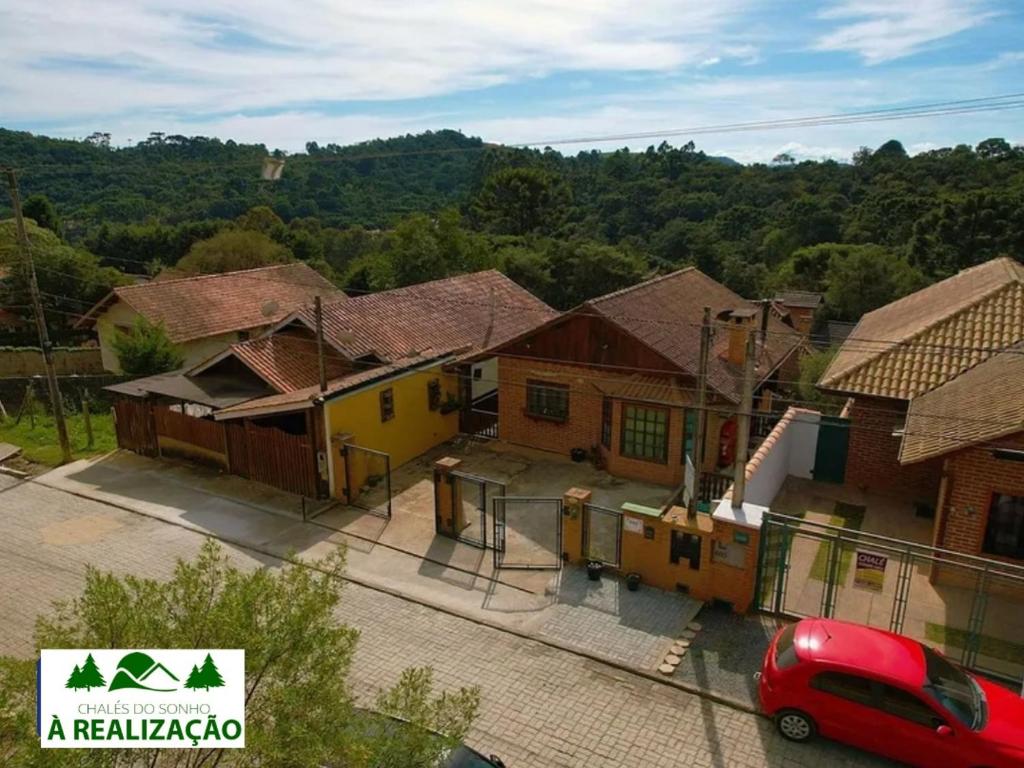 a red car parked in front of a row of houses at Do Sonho a Realizacao in Monte Verde