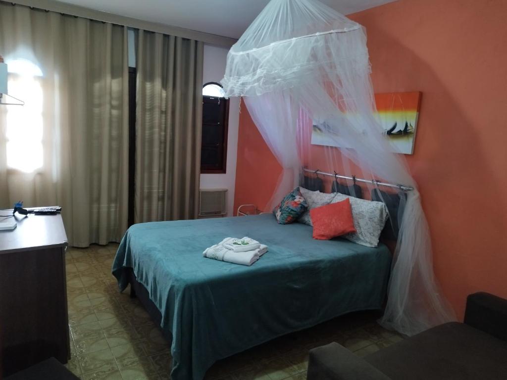 um quarto com uma cama e uma rede mosquiteira em Arraial do Cabo - Suite luxo em Arraial do Cabo