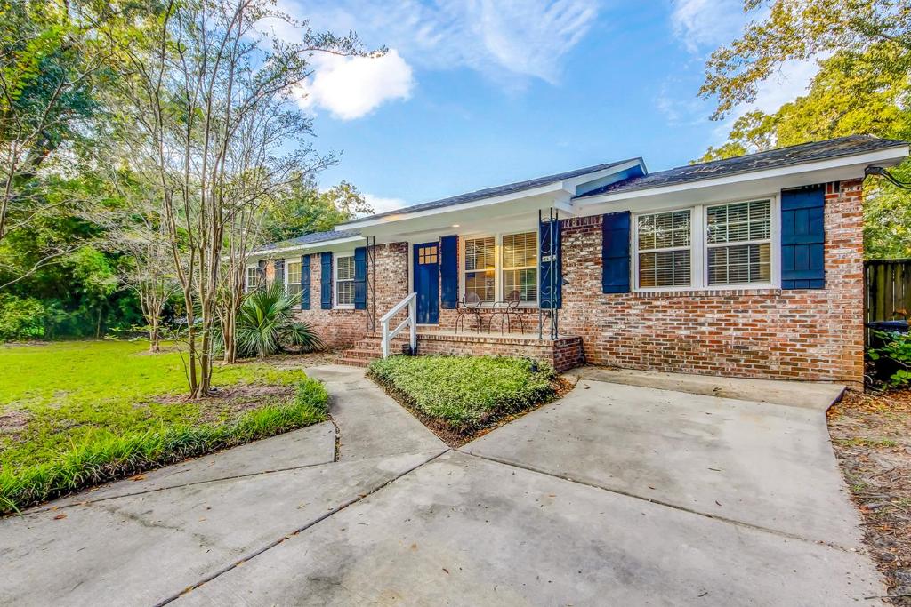 a brick house with blue windows and a driveway at Pleasant Dreams in Charleston