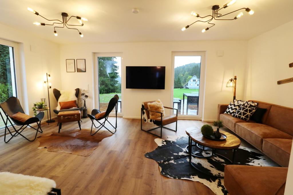 sala de estar con sofá, sillas y TV en Design-Ferienhaus "auf der Schanz" mit privater Sauna - Todtnau-Muggenbrunn, Feldberg im Schwarzwald en Muggenbrunn