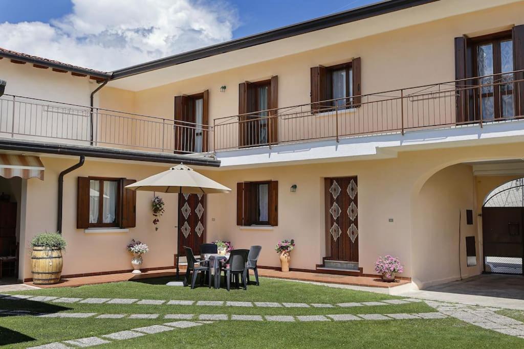 a house with a table and chairs and an umbrella at La casa di Mario e Olga in San Martino