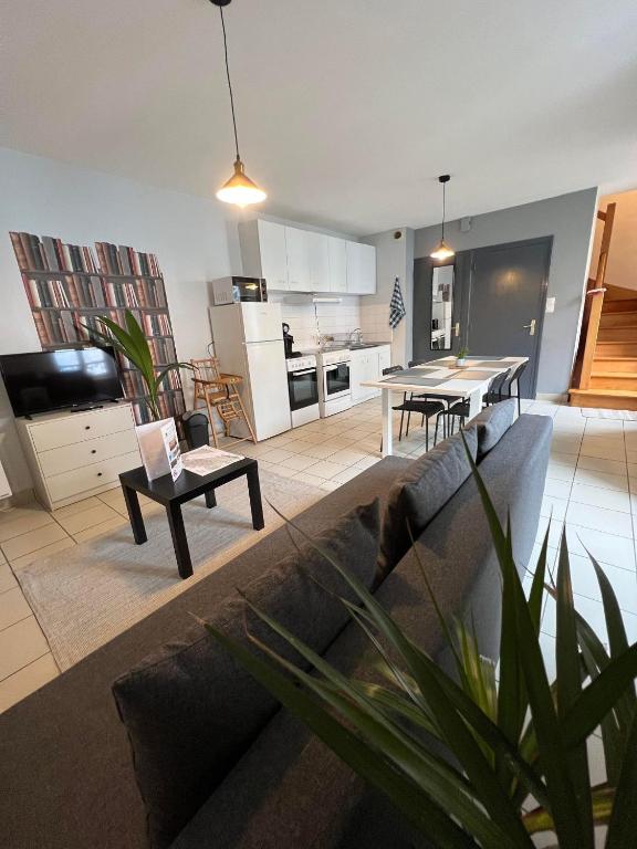 un salon avec un canapé et une cuisine dans l'établissement T3 50m2 Lumineux proche mairie - plein centre, à Carhaix-Plouguer