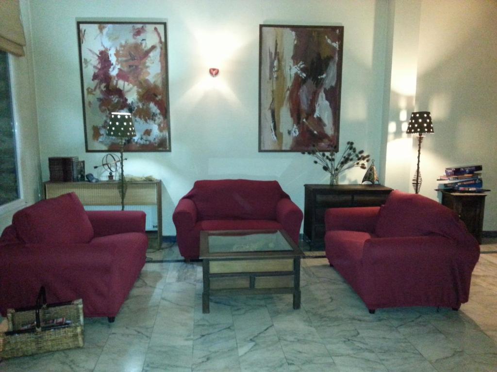 a living room with two red chairs and a table at Hotel La Brañina in Villablino