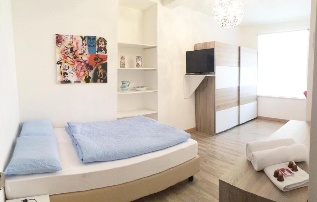 1 dormitorio pequeño con 1 cama y TV en Rosengarten en Bolzano